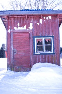 Lumiauran puumerkki antaa oman sävynsä Toivolan postimökille. Kodikas pitsiverhoinen ikkuna kätkee taakseen viehättävän pikkuhuoneen, jossa on pöytä, penkki ja räsymatto.